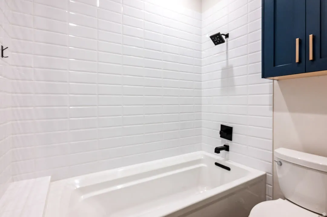 Full bath featuring toilet and washtub / shower combination