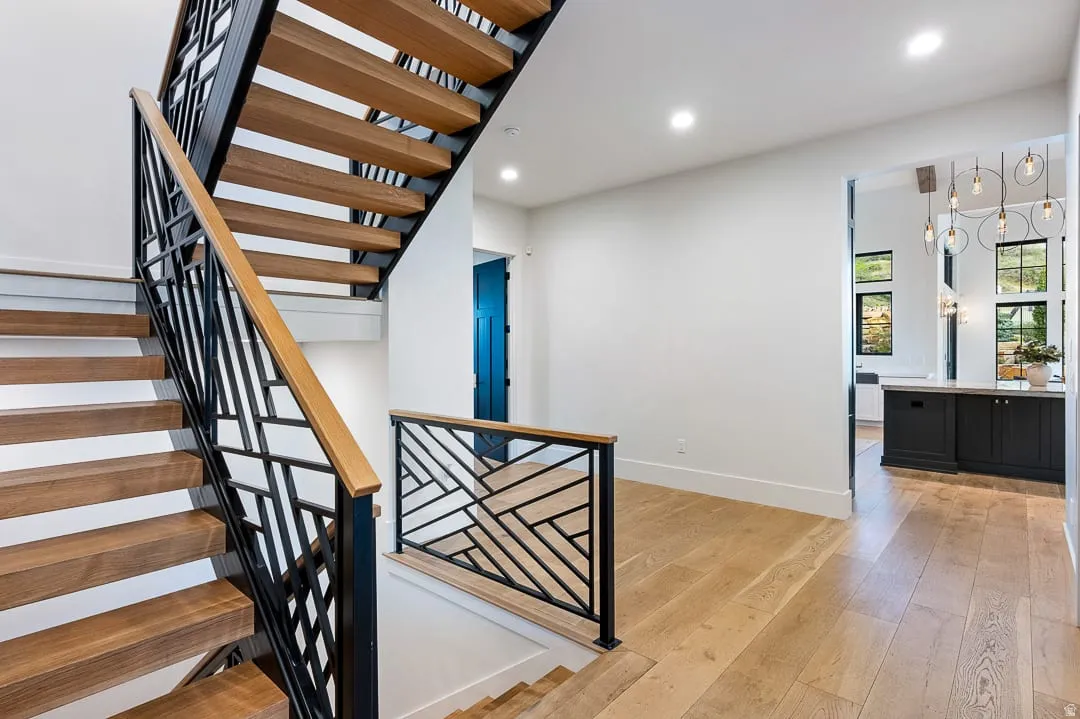 Stairs with hardwood / wood-style floors and recessed lighting