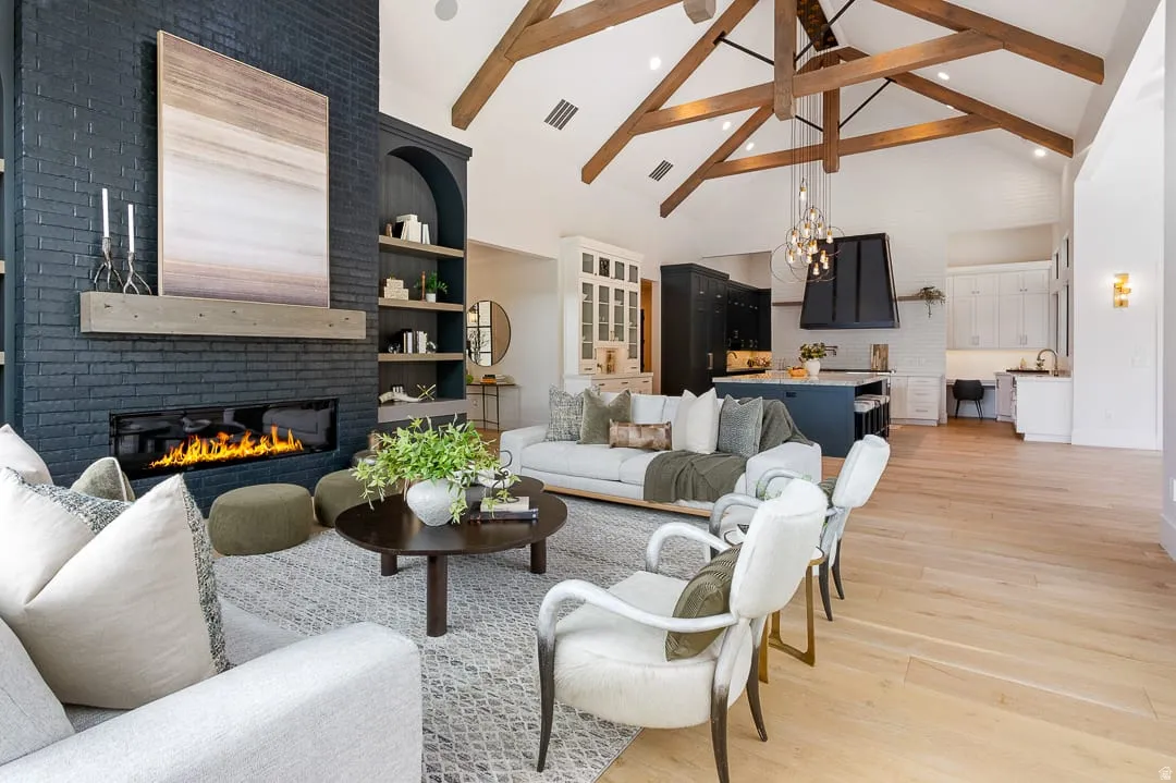 Living area with light wood-type flooring, suspended lighting, and a brick fireplace