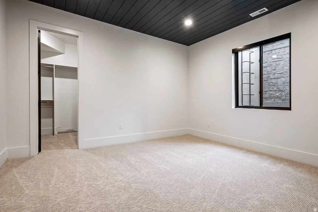 Spare room featuring wooden ceiling, light colored carpet, and recessed lighting