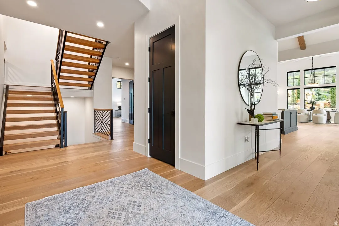 Corridor featuring light wood-style flooring, recessed lighting, and beamed ceiling