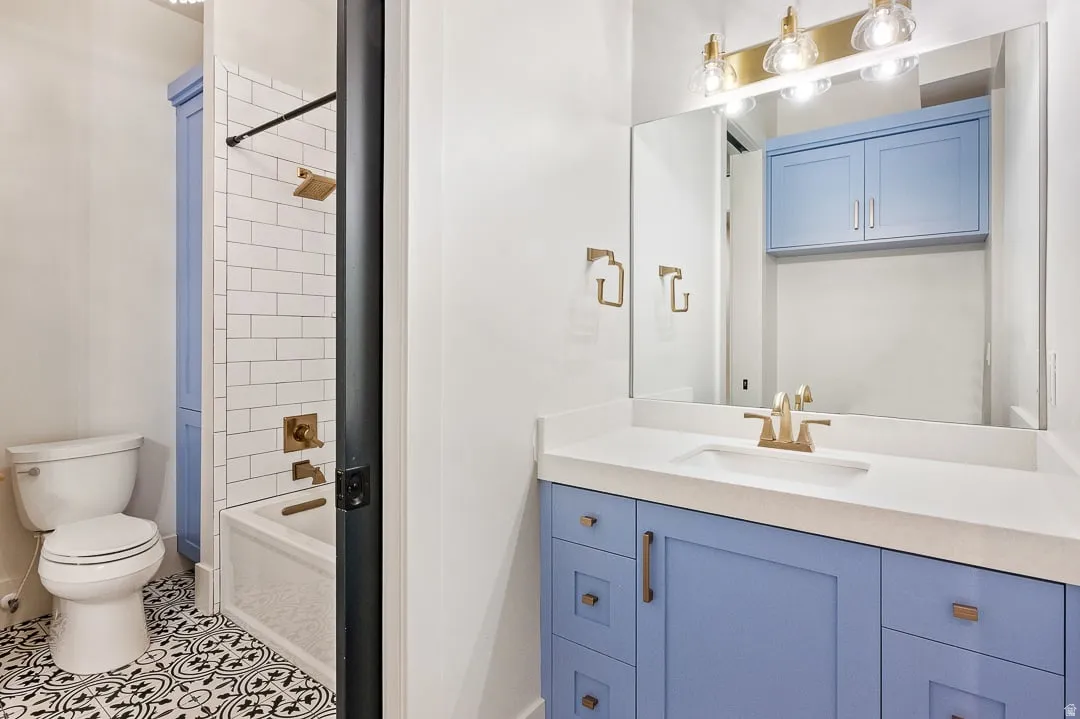 Full bathroom with vanity, tub / shower combination, and tile patterned flooring