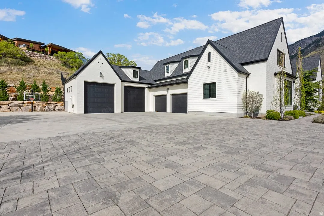 View of side of home with concrete driveway and an attached garage