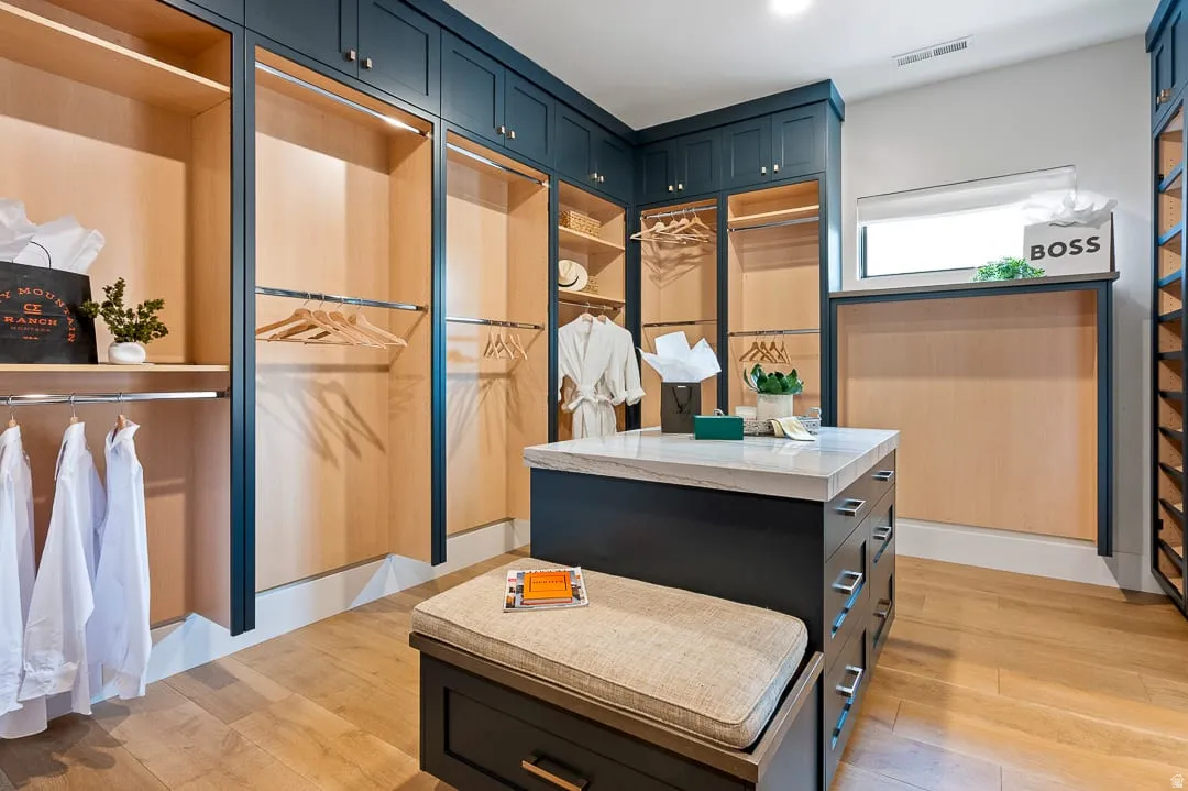Bathroom featuring light wood finished floors and a spacious closet