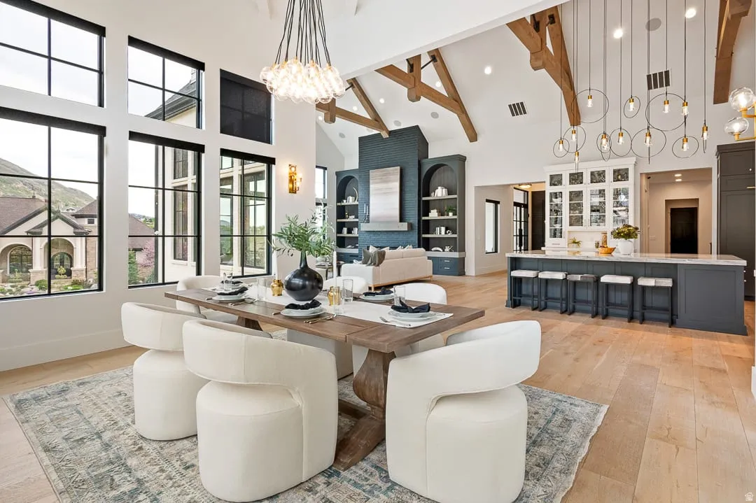 Dining space with a chandelier, light wood finished floors, and vaulted ceiling
