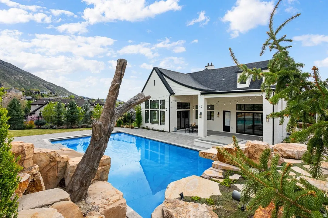 View of swimming pool with patio surround and a mountain view