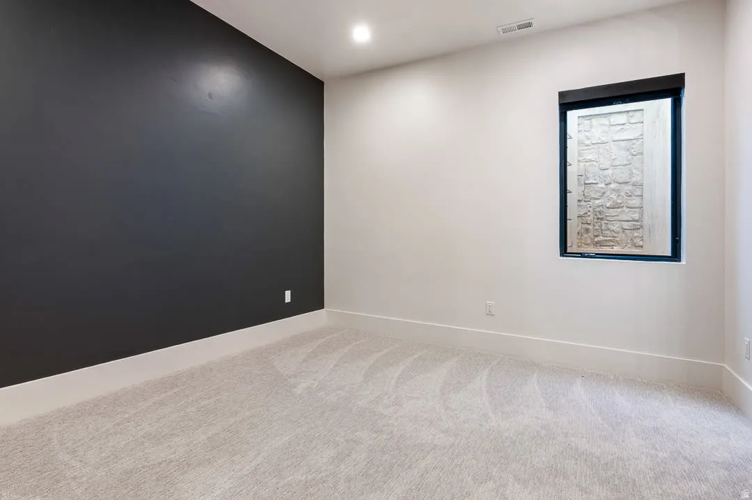 Empty room with recessed lighting and light carpet