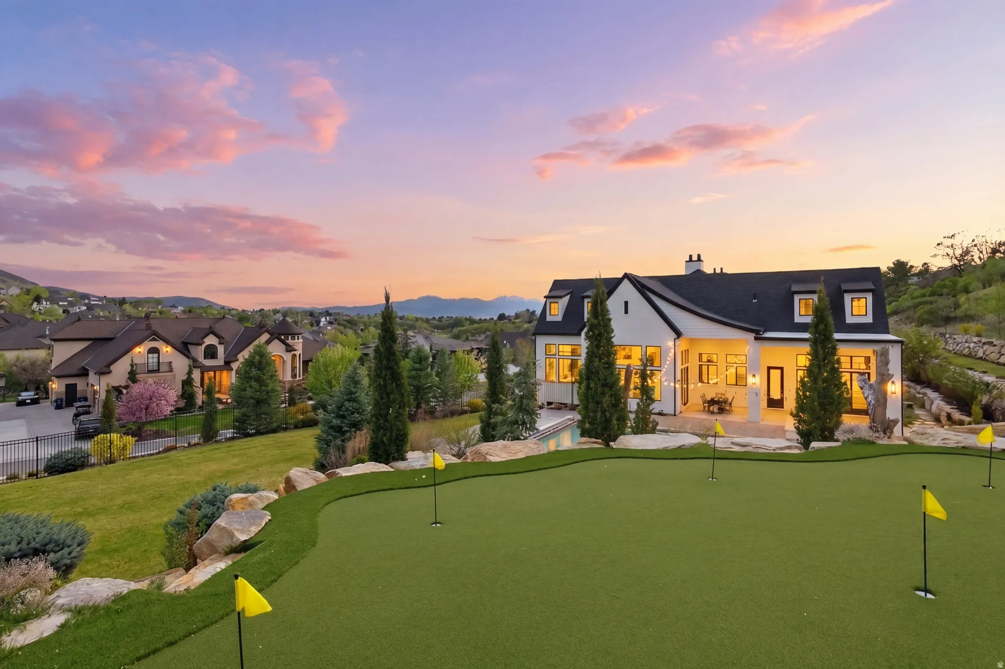 Back of property featuring a chimney, a putting area, and a patio