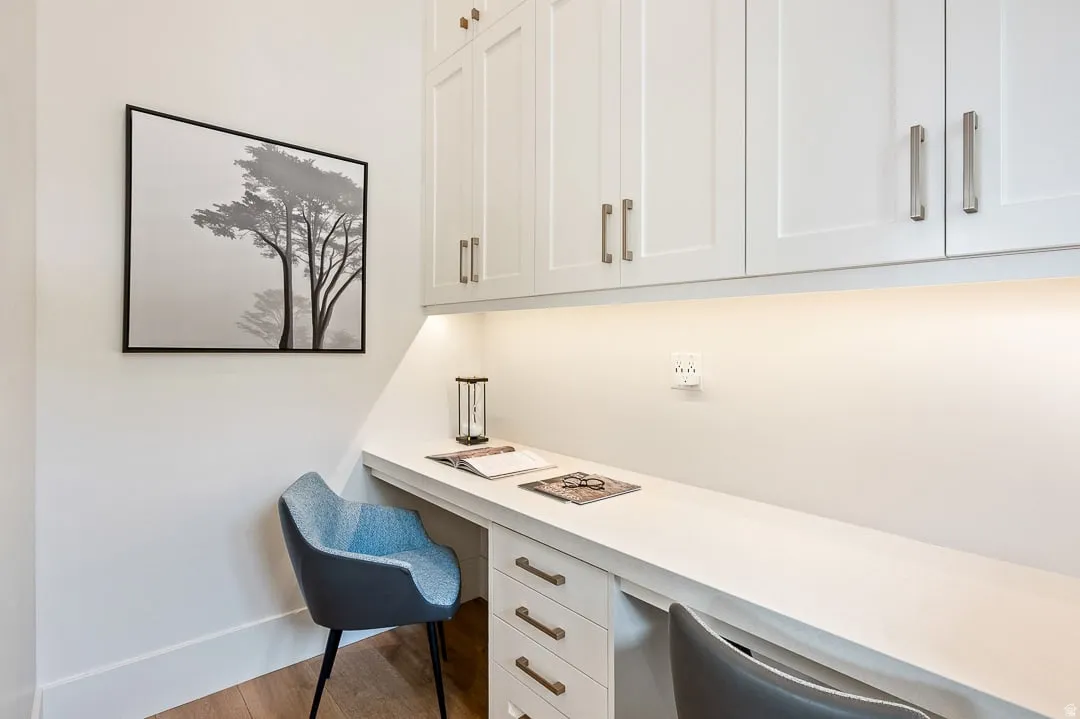 Office featuring built in study area and wood finished floors