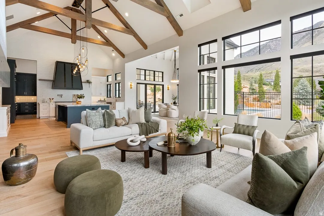 Living area featuring light wood-style flooring, vaulted ceiling, and suspended lighting