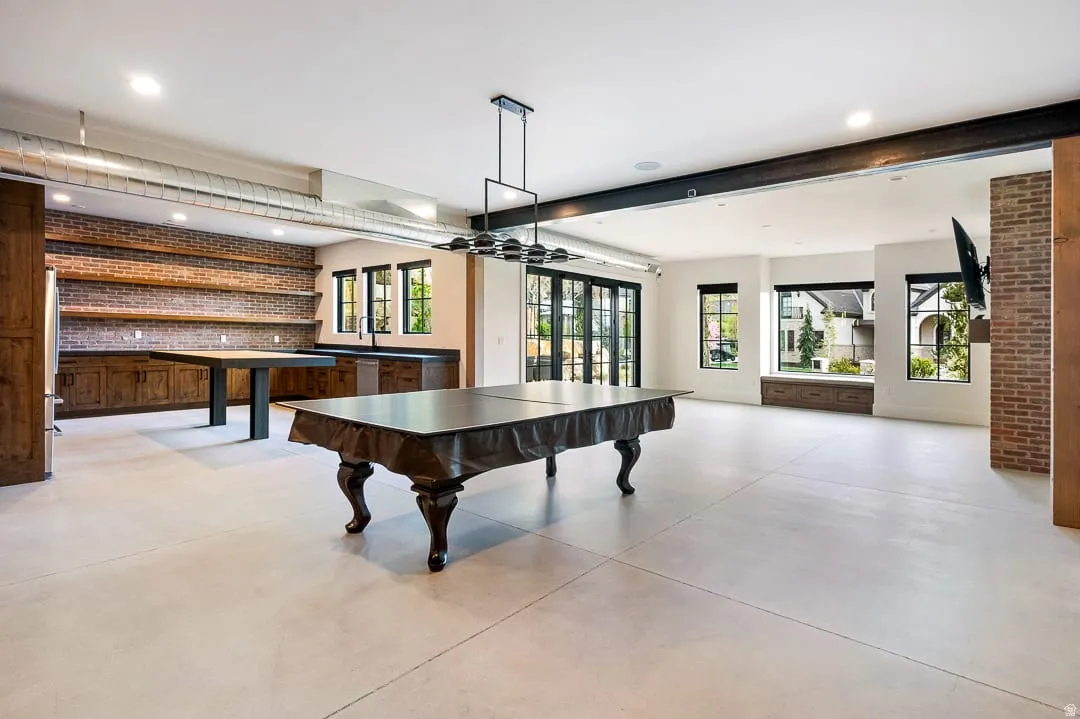 Rec room with recessed lighting and brick wall