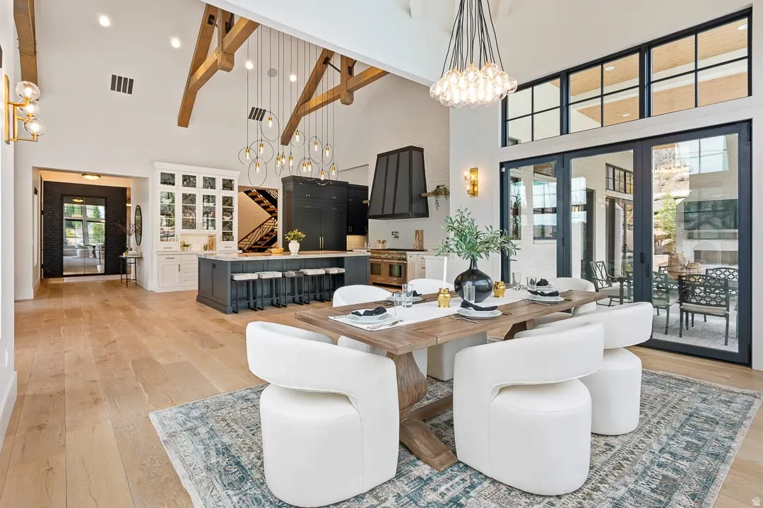 Dining space featuring a high ceiling, light wood finished floors, and a chandelier