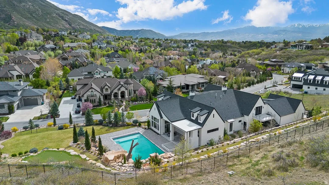 Aerial view of residential area featuring mountains and a pool