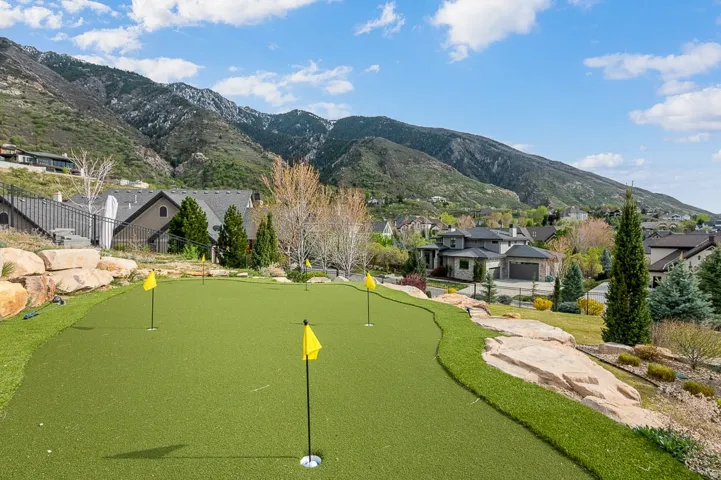 View of property's community with a mountain view, an area to practice putting, and a residential view
