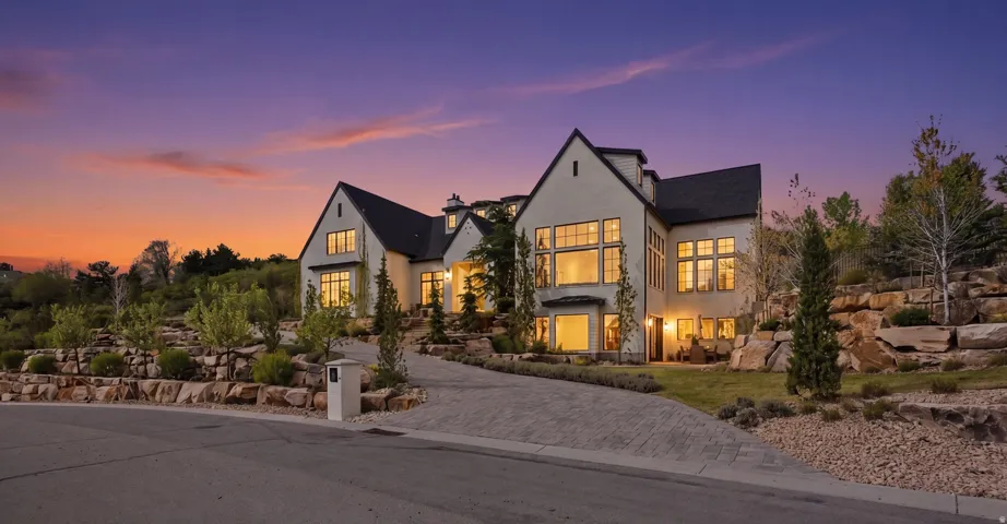 View of front of house featuring stucco siding, a chimney, and a balcony