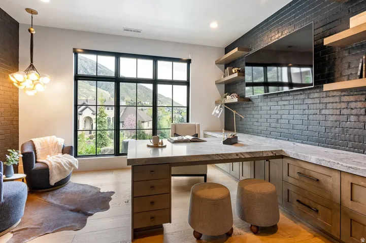 Home office featuring brick wall and light wood-type flooring