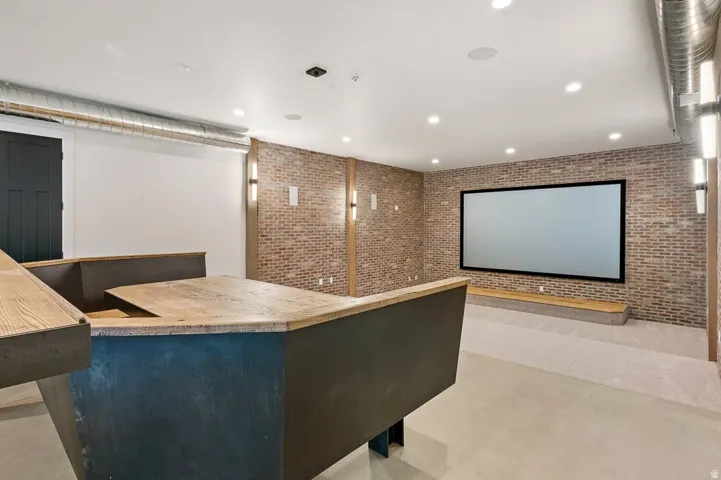 Cinema with brick wall, recessed lighting, and a community bar