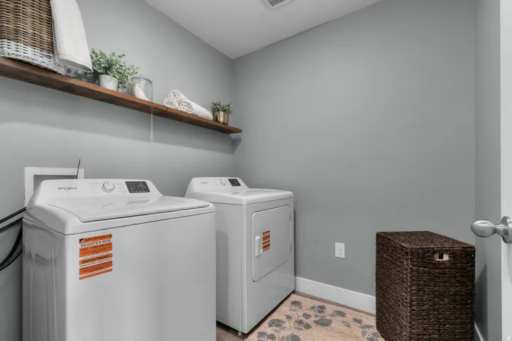 Laundry room with separate washer and dryer and light wood-style flooring