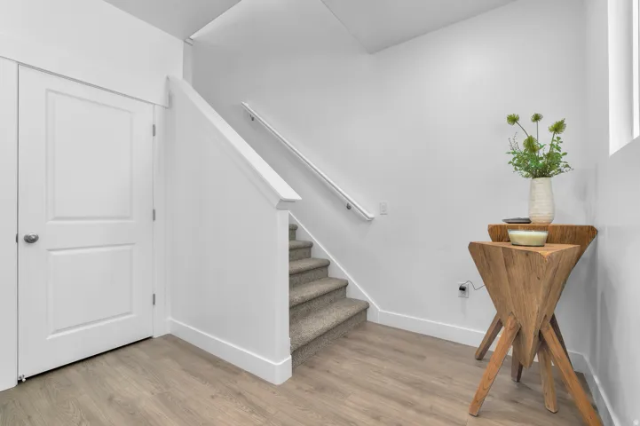 Staircase with wood finished floors and baseboards