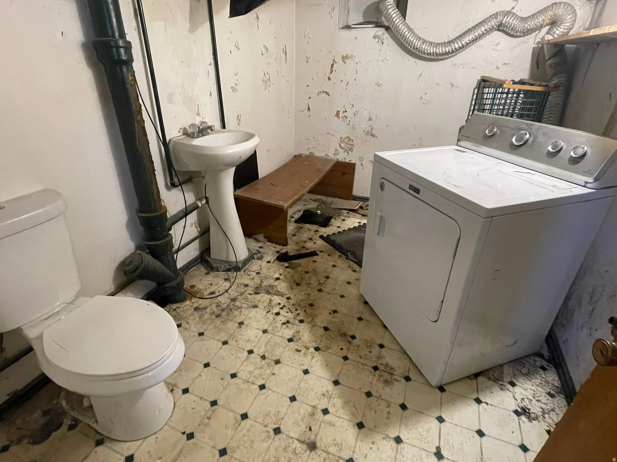Downstairs half bath and laundry area.  Plenty of room to make this a full bathroom.