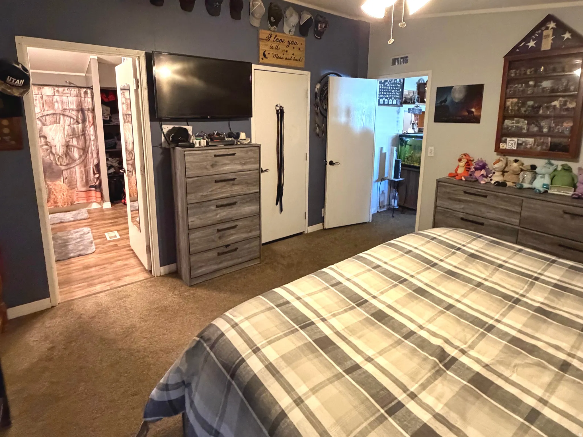 Bedroom featuring dark colored carpet, a ceiling fan, ornamental molding, and ensuite bathroom