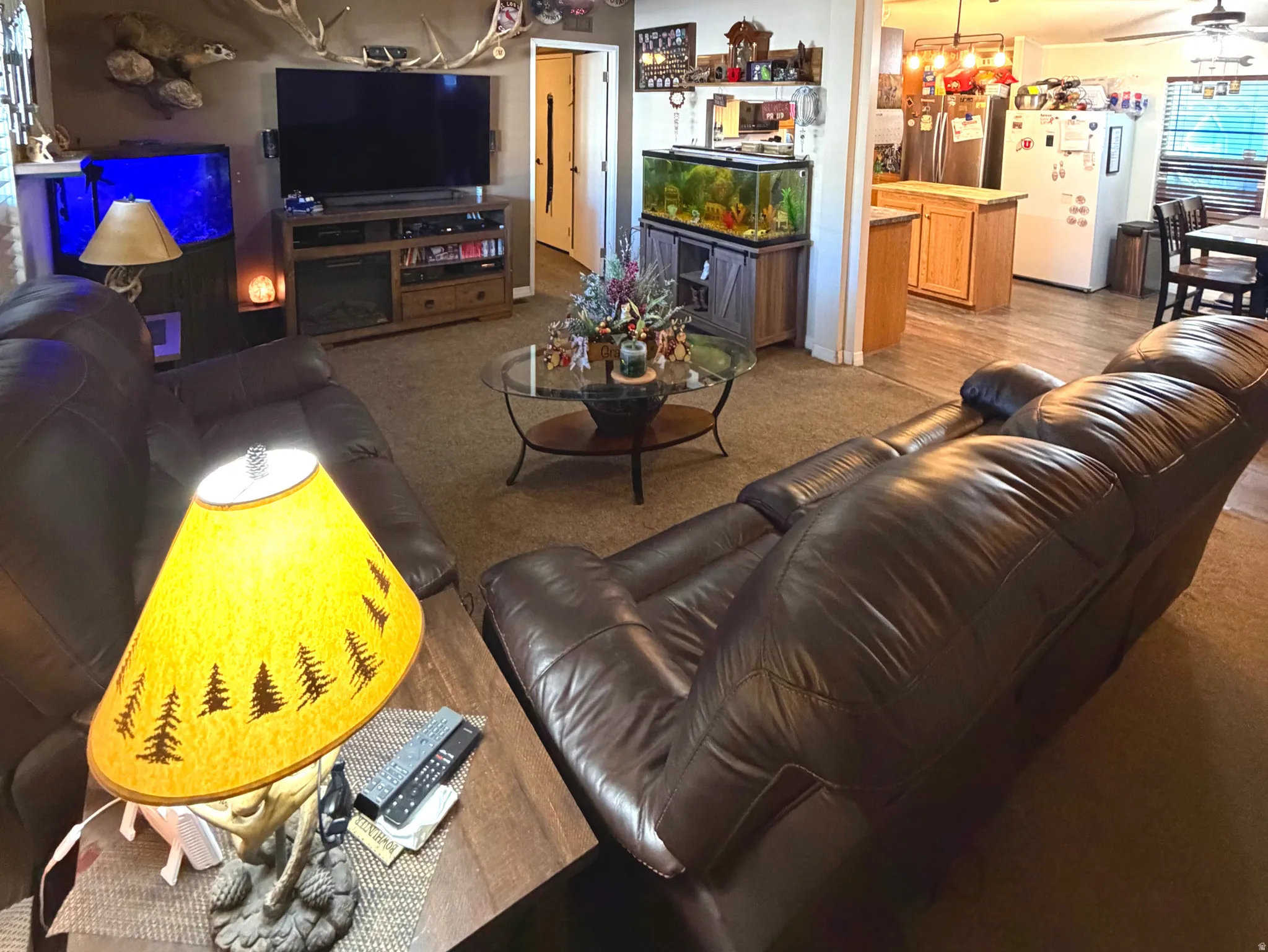 Living room with a ceiling fan, wood finished floors, and hanging lights