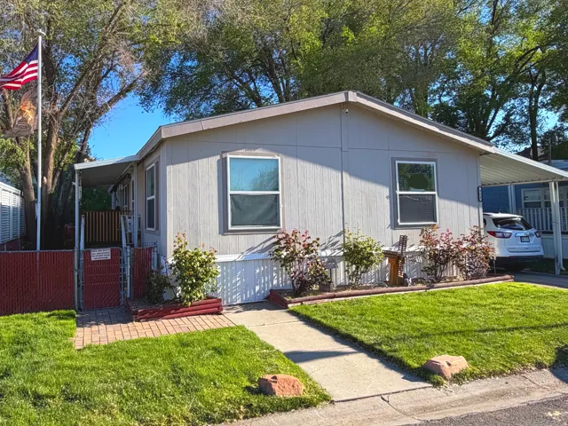 Manufactured / mobile home with a gate and an attached carport
