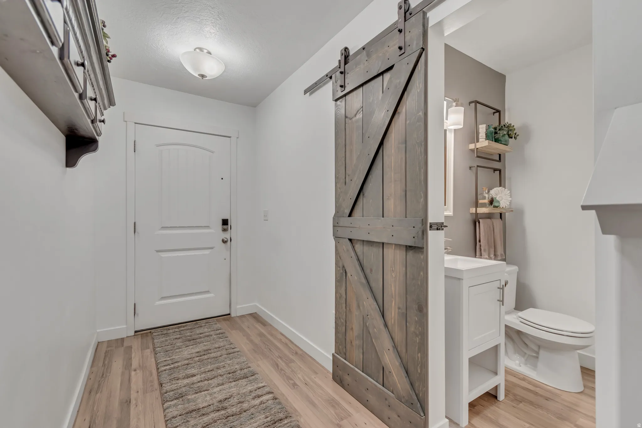 Foyer featuring a barn door and light wood-style floors