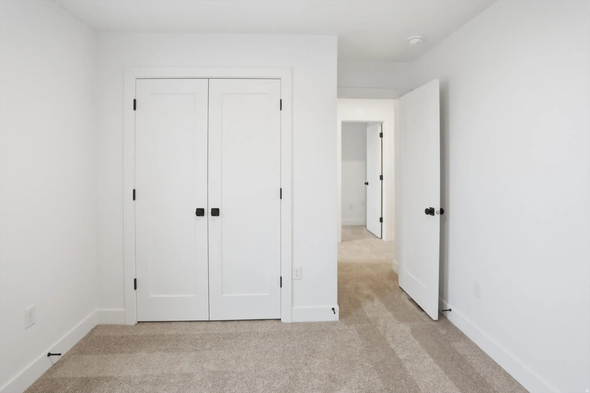 Unfurnished bedroom featuring light colored carpet and a closet