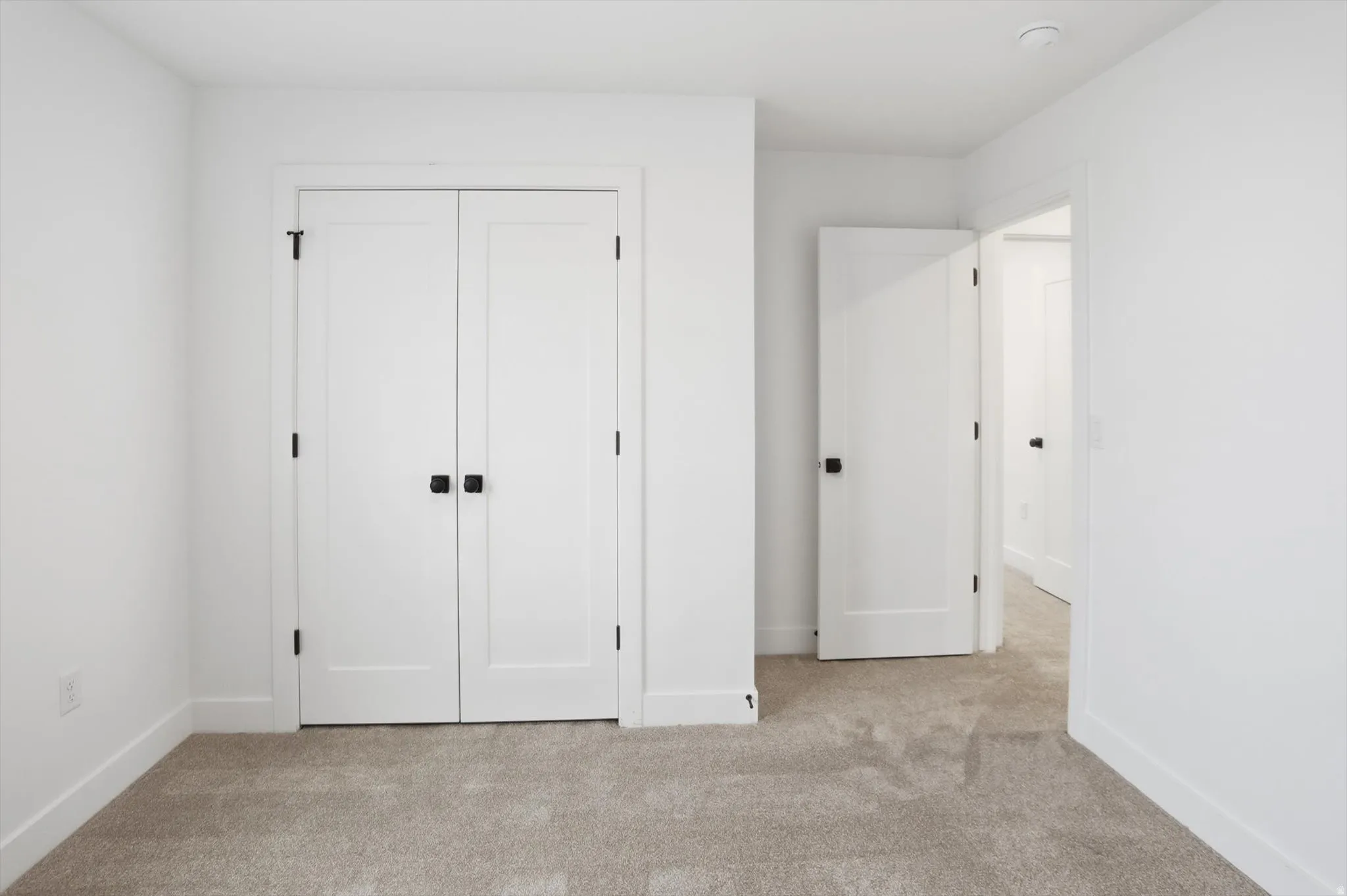 Unfurnished bedroom with light colored carpet and a closet