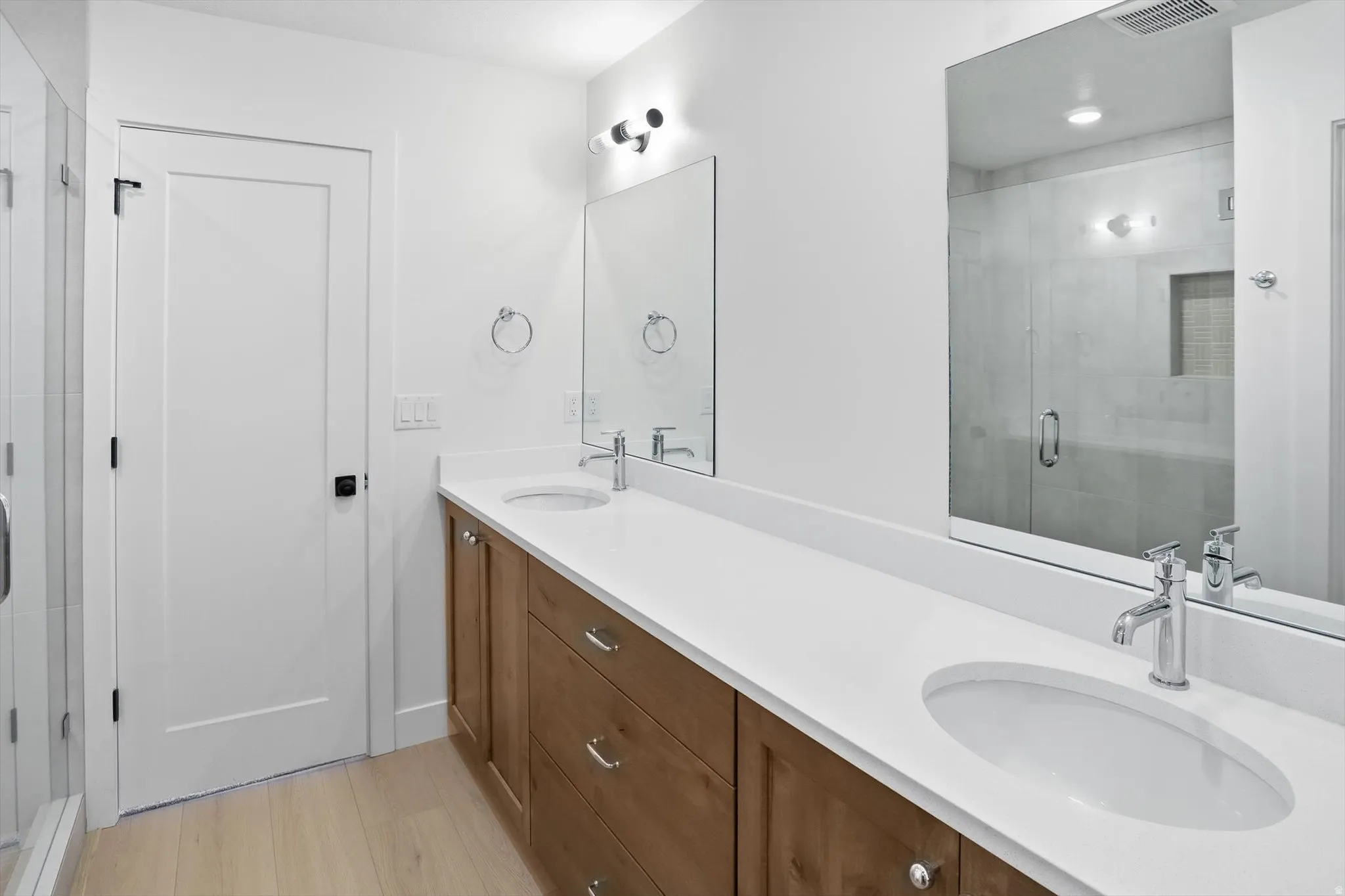 Full bathroom with a shower stall and double vanity