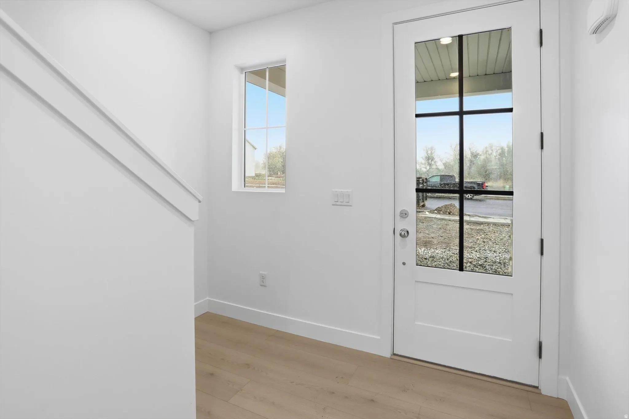 Doorway with baseboards and wood finished floors