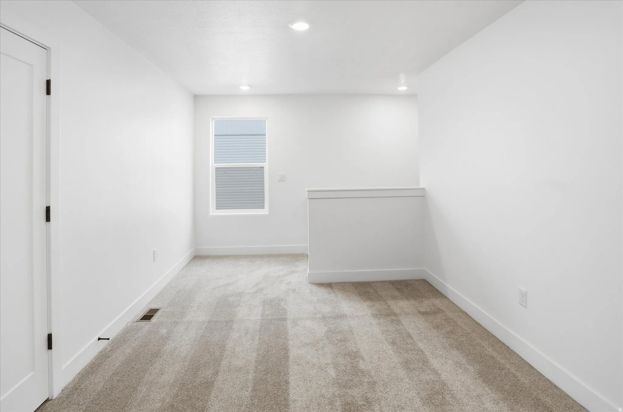 Empty room featuring light colored carpet and recessed lighting