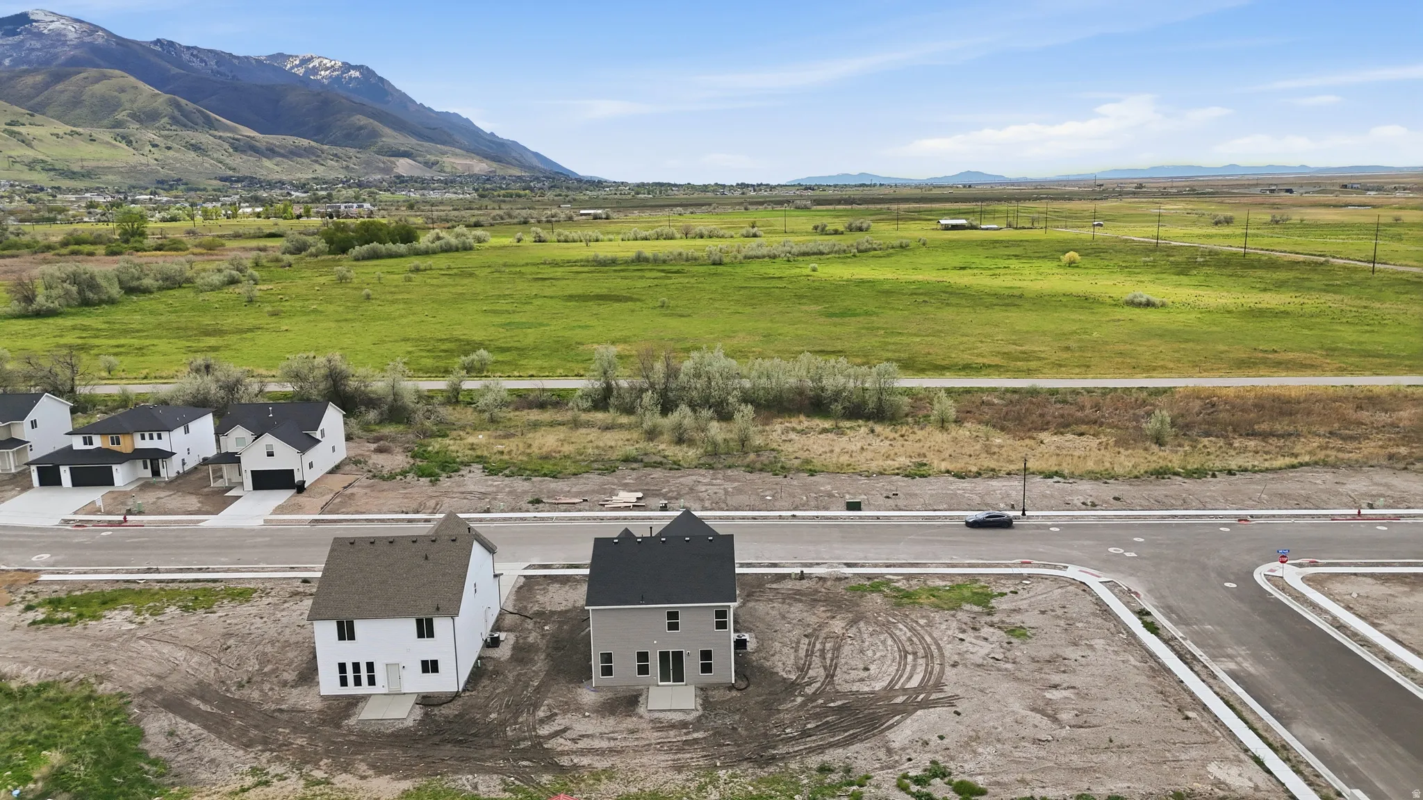 View of rural area with a mountain backdrop and agricultural land