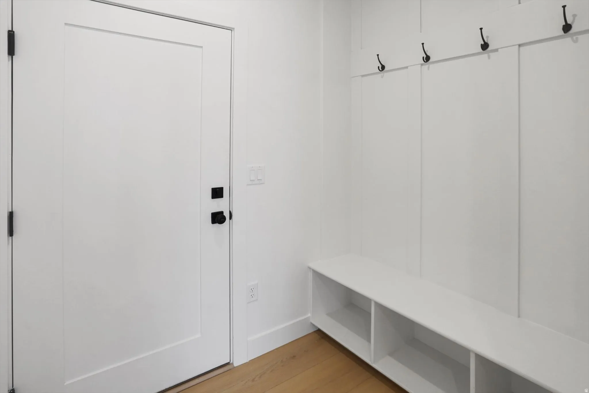 Mudroom featuring light wood-style floors and baseboards