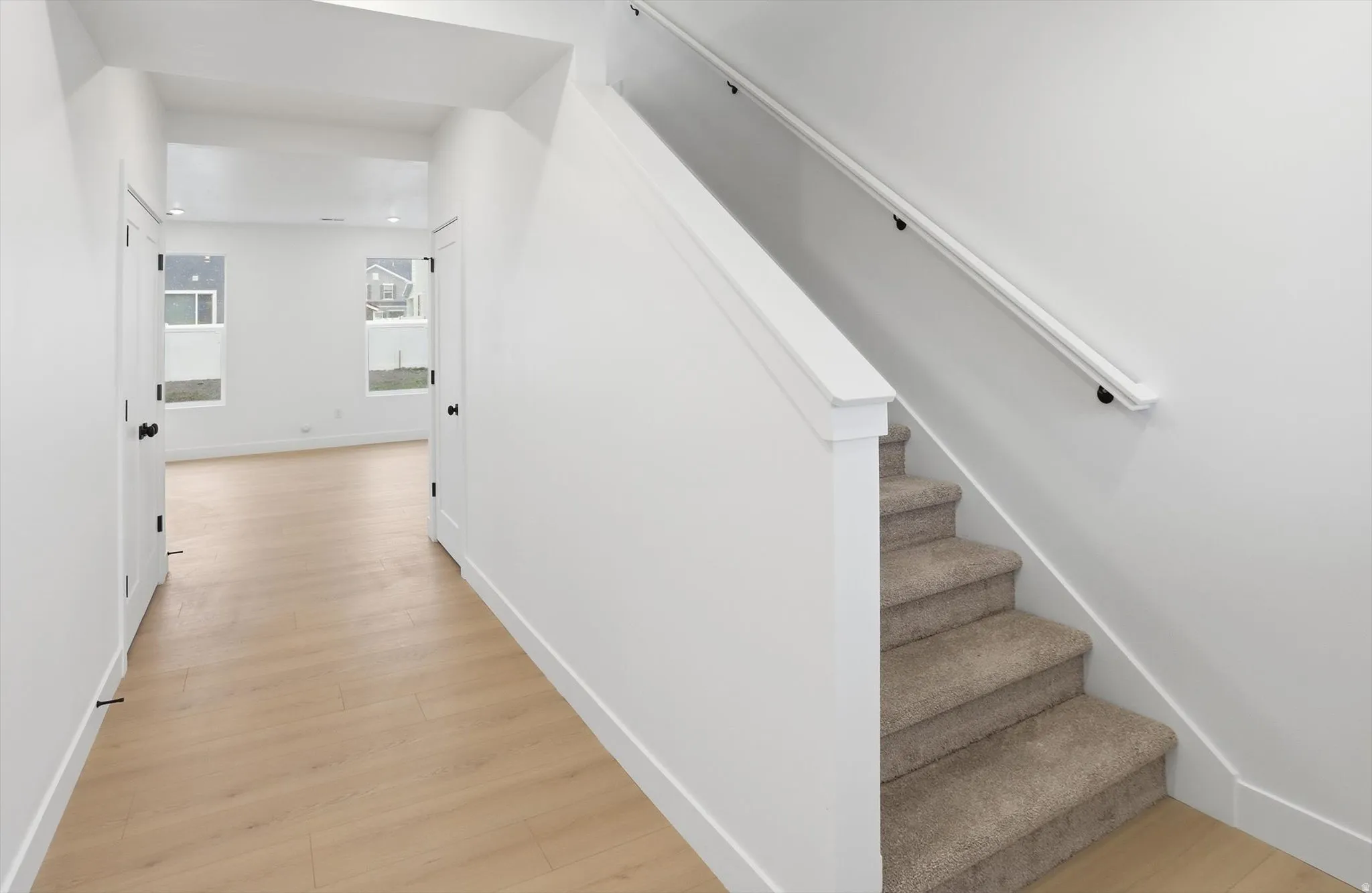 Stairway featuring wood finished floors and recessed lighting
