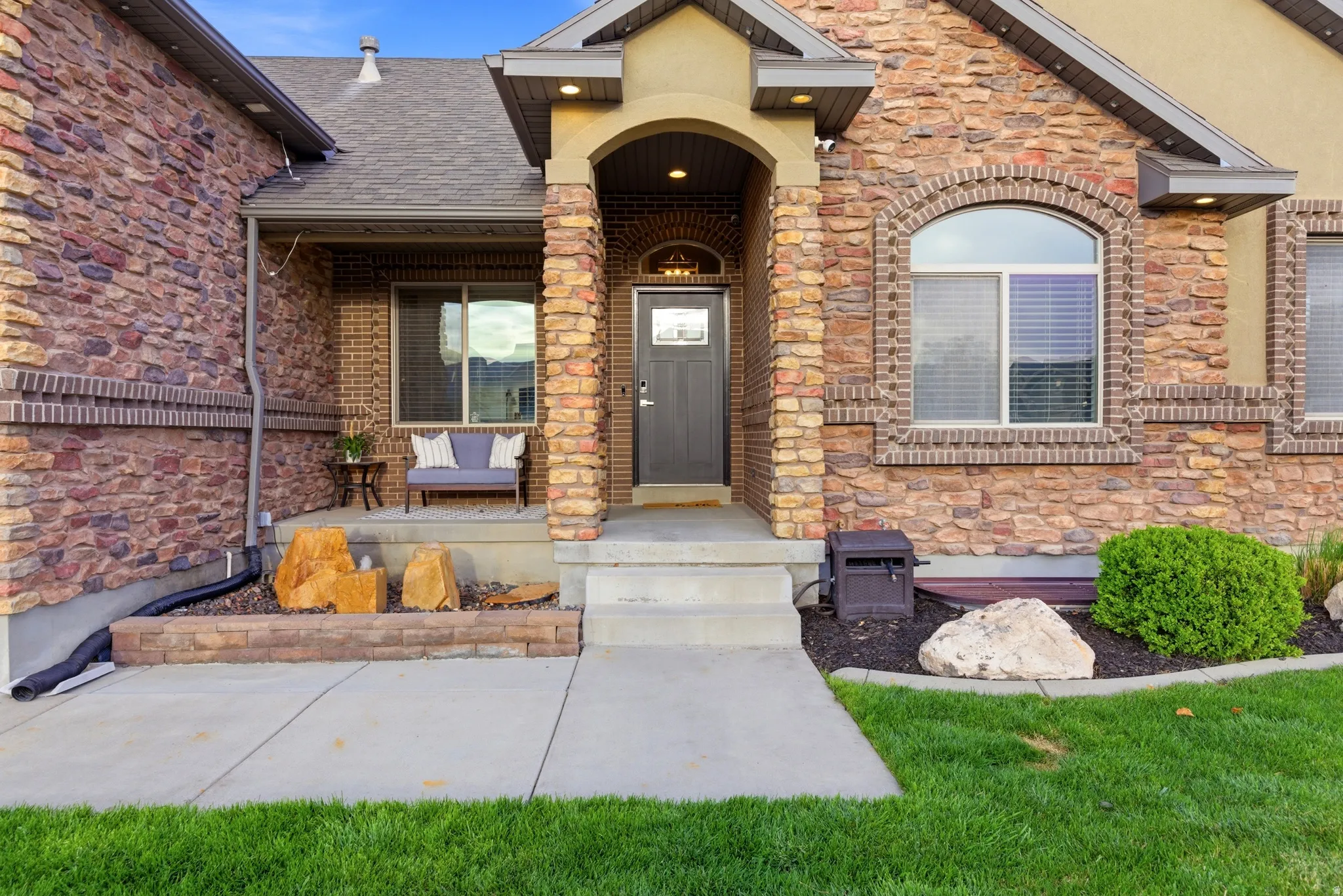 View of exterior entry with stone siding and a porch