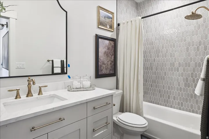 Full bath featuring vanity and shower / bath combination with curtain
