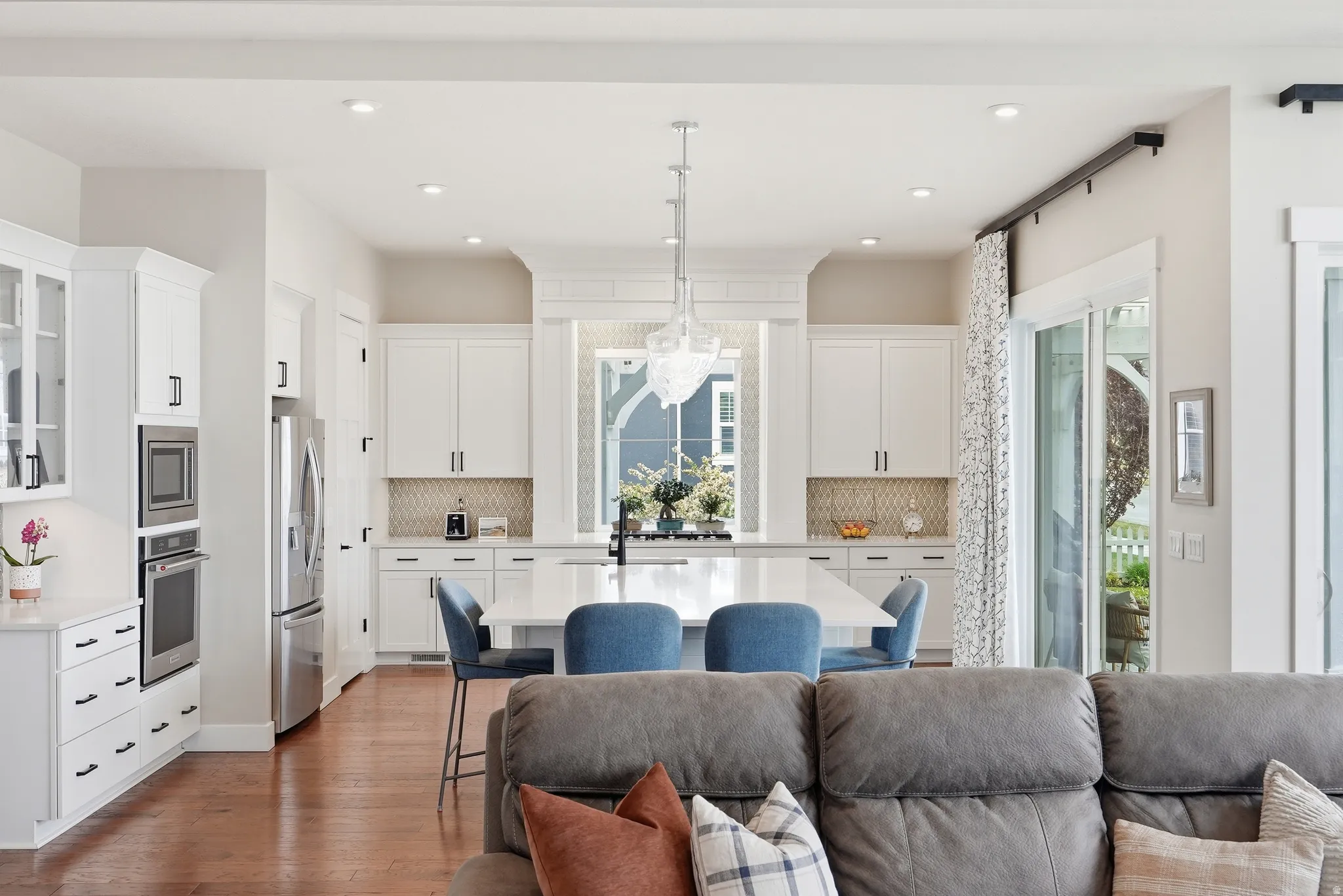 Kitchen featuring white cabinets, open floor plan, and an island with sink