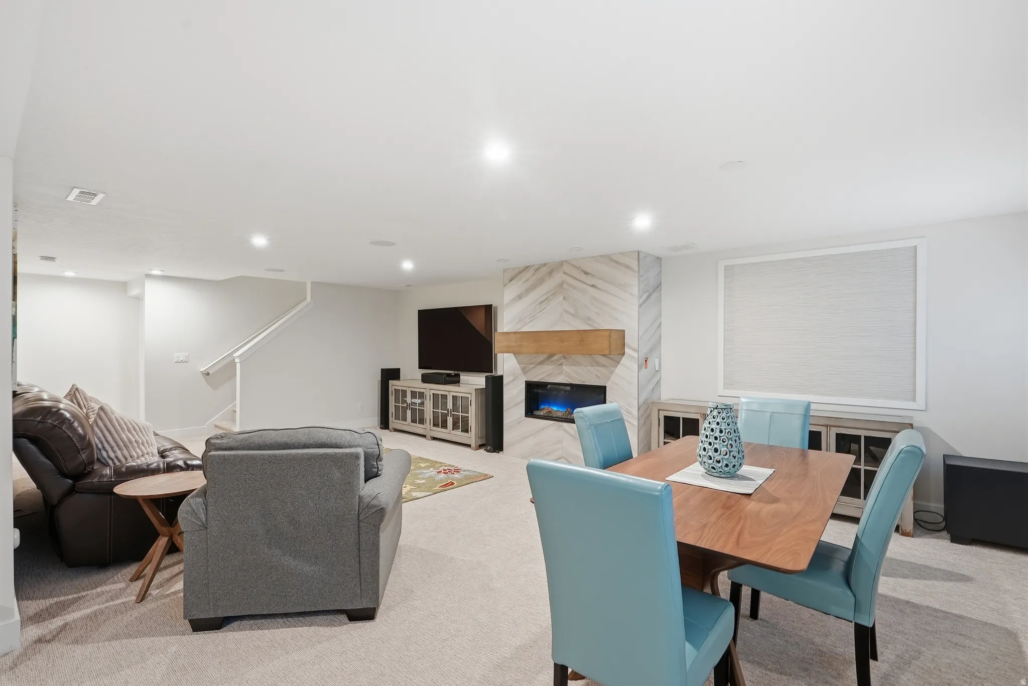 Dining room featuring light carpet, a fireplace, and recessed lighting