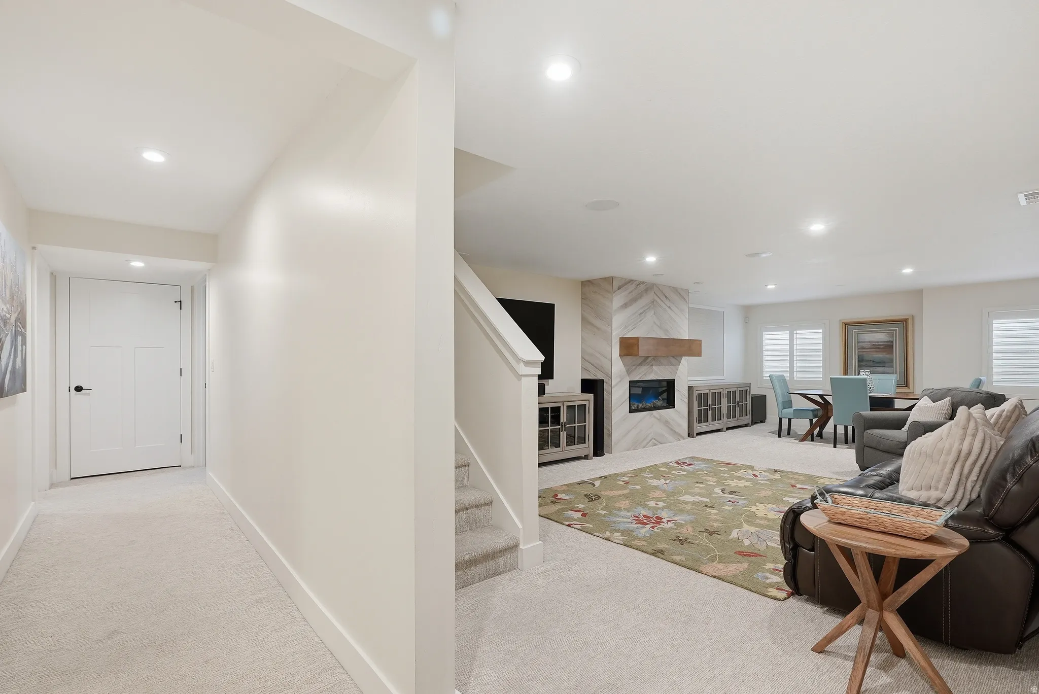 Living area with light colored carpet, recessed lighting, and a premium fireplace