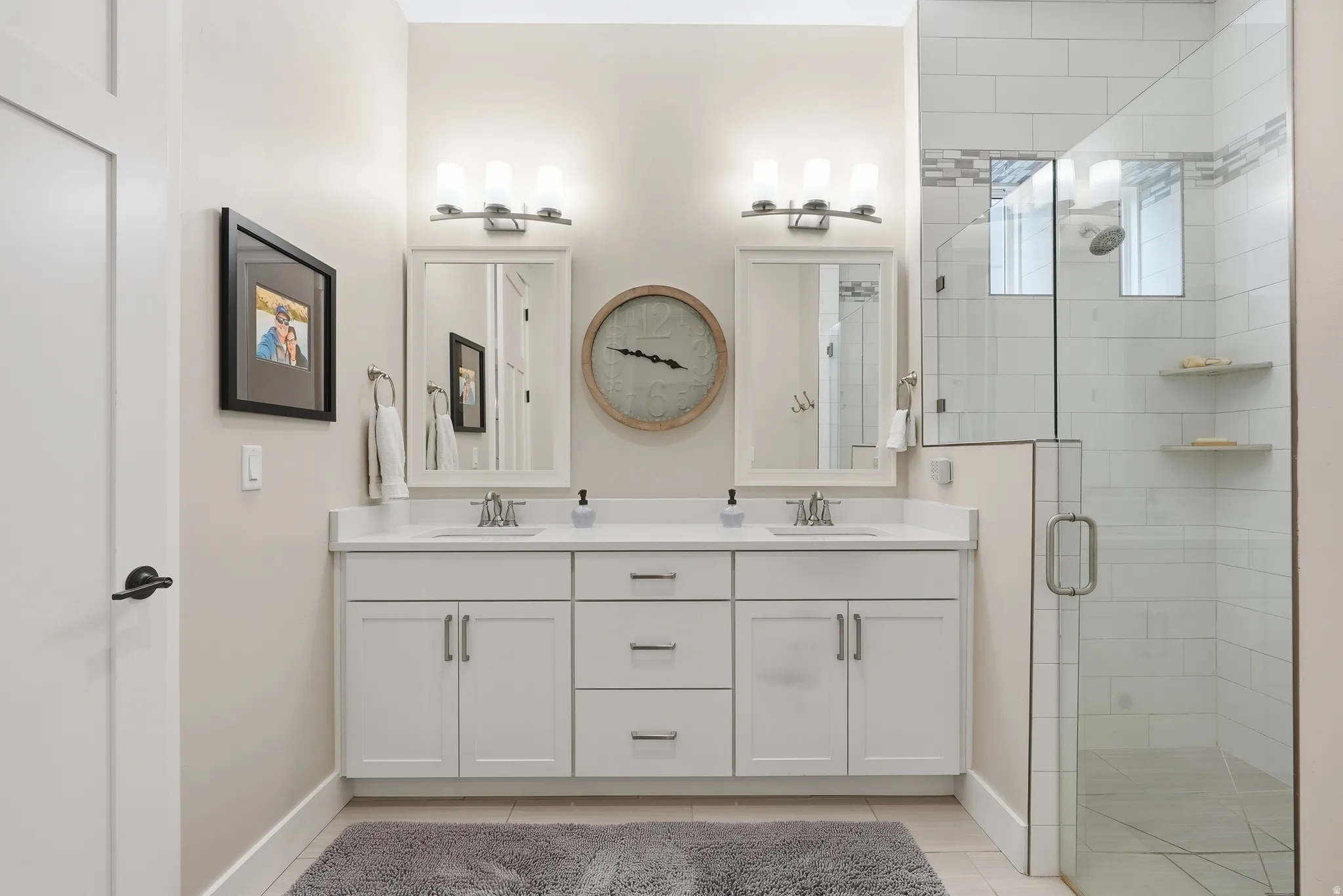 Bathroom featuring double vanity and a shower stall