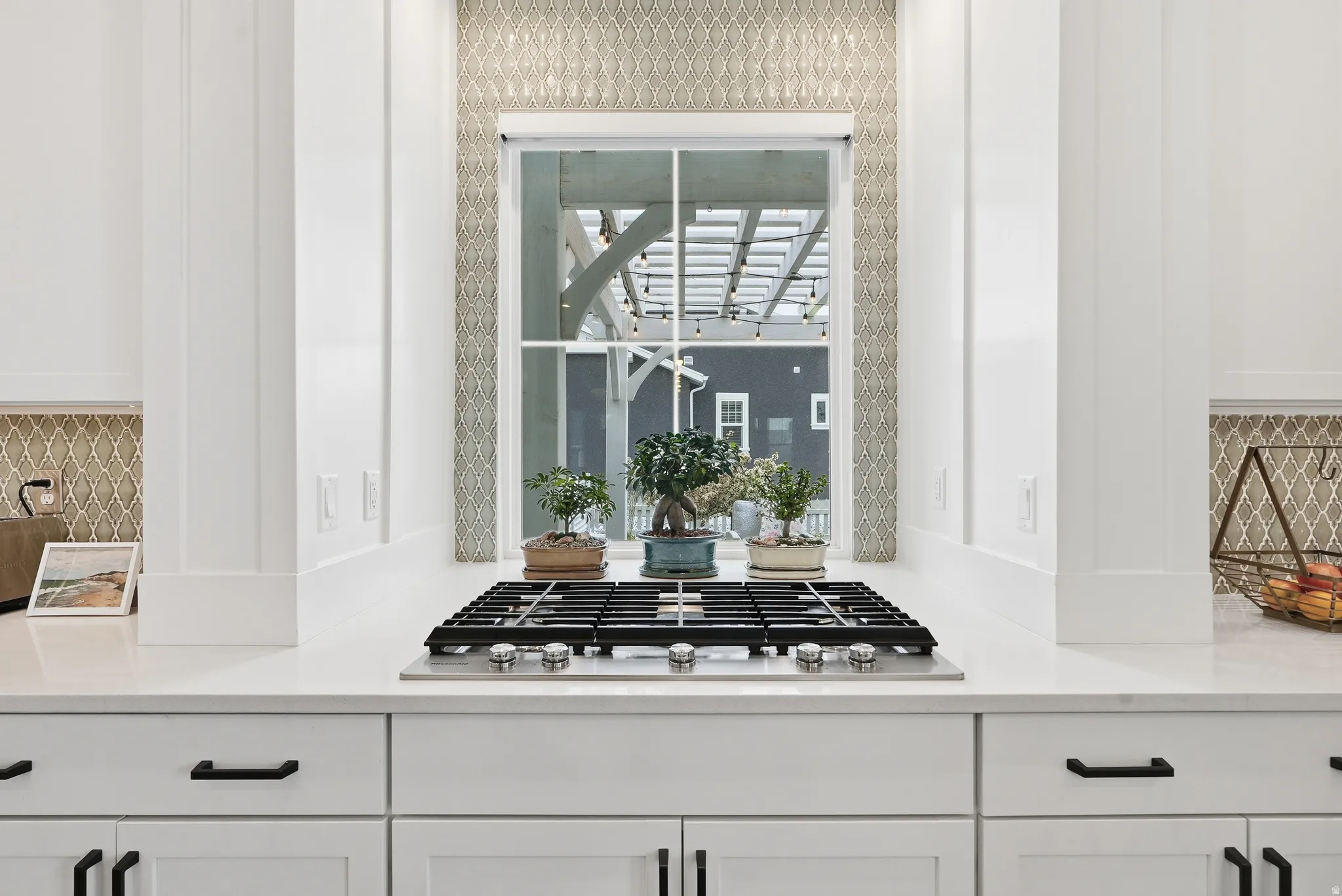 Kitchen featuring white cabinets, tasteful backsplash, and light stone countertops