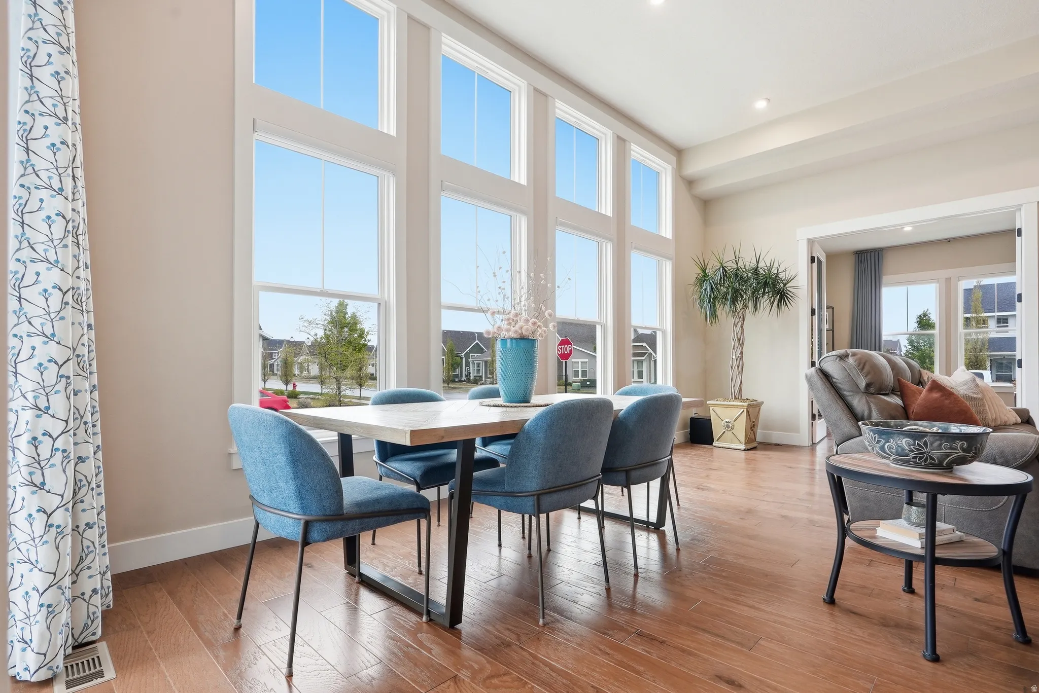 Dining area with light wood-type flooring, recessed lighting, and a high ceiling