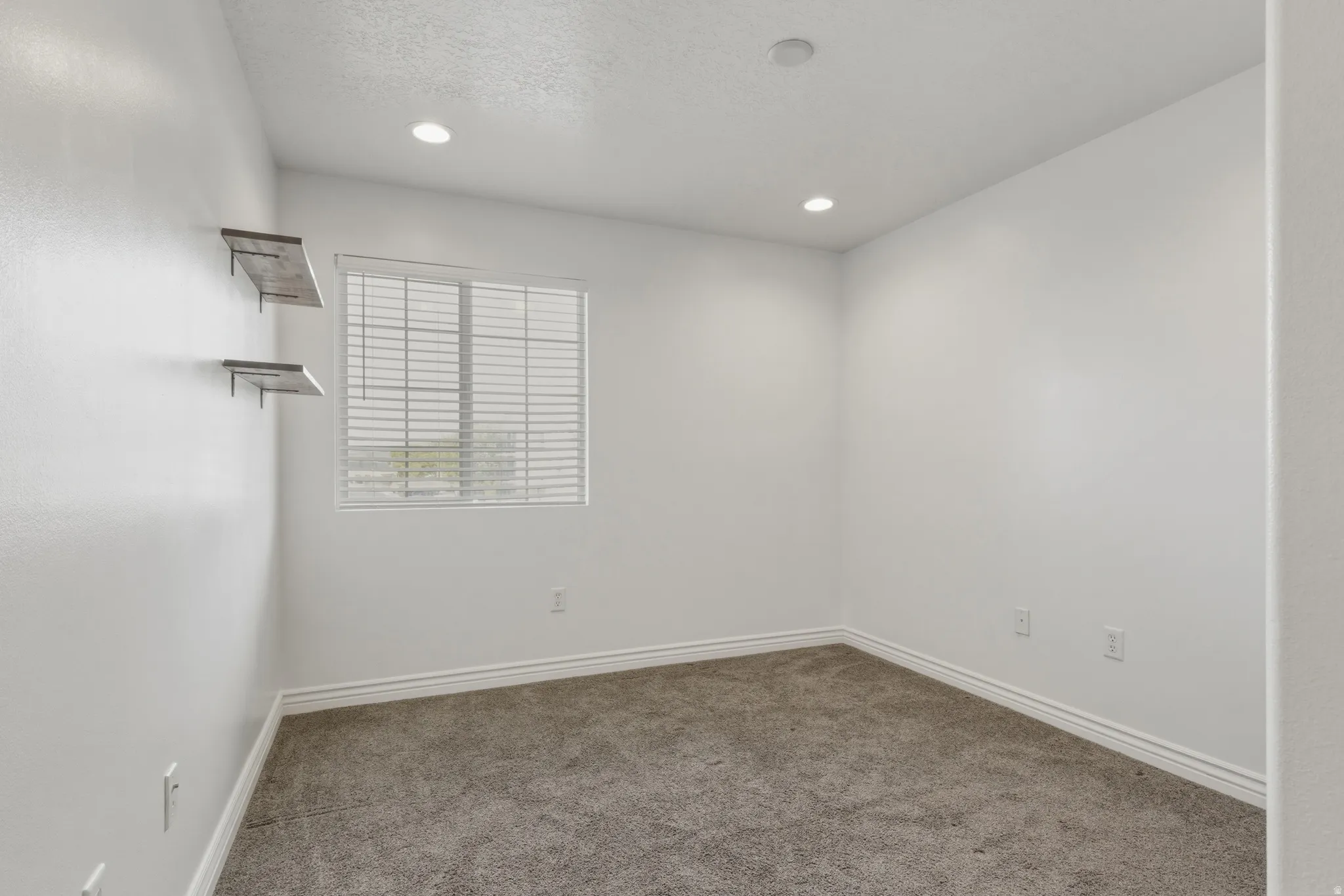 Unfurnished room featuring light carpet, a textured ceiling, and recessed lighting
