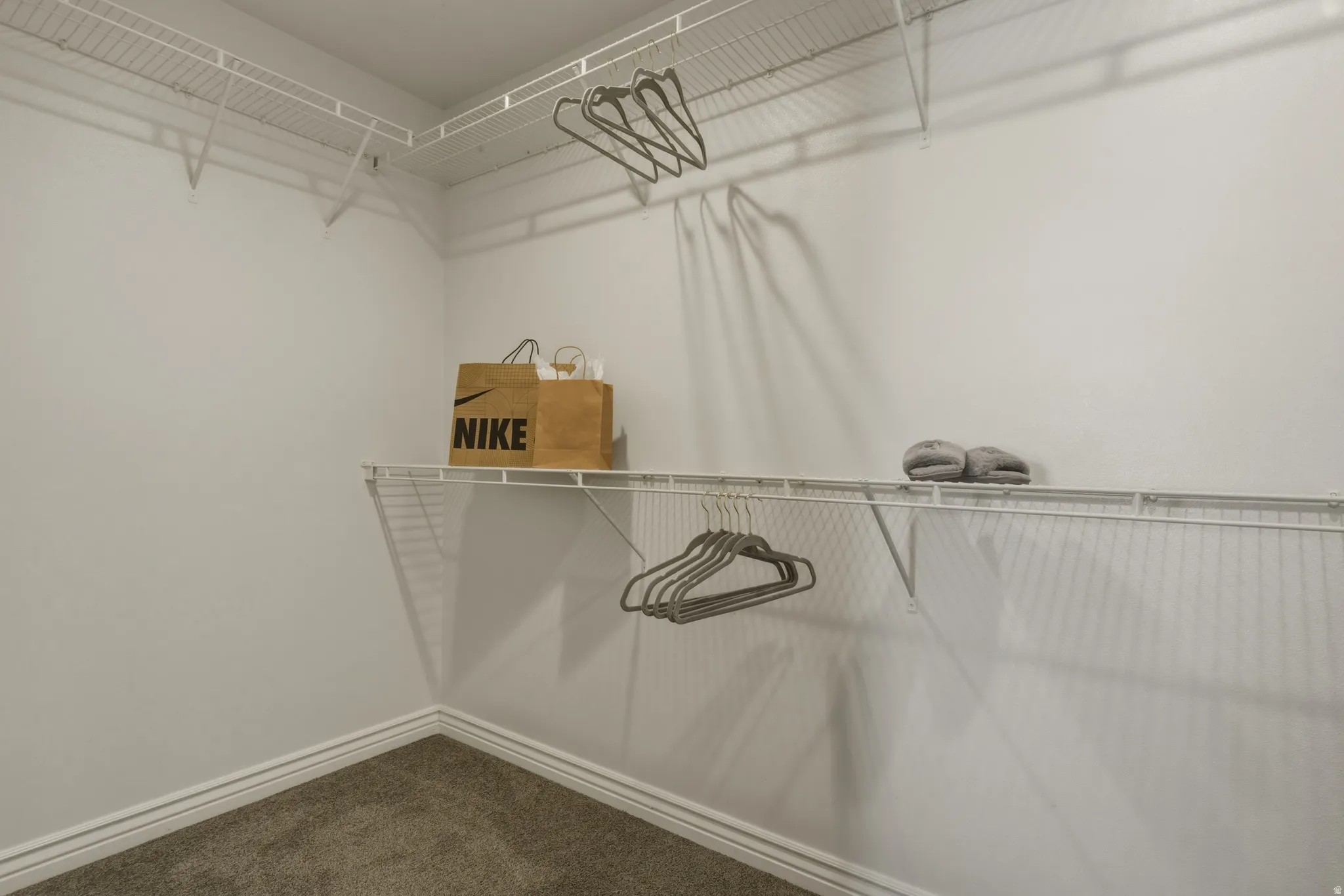 Walk in closet featuring dark colored carpet