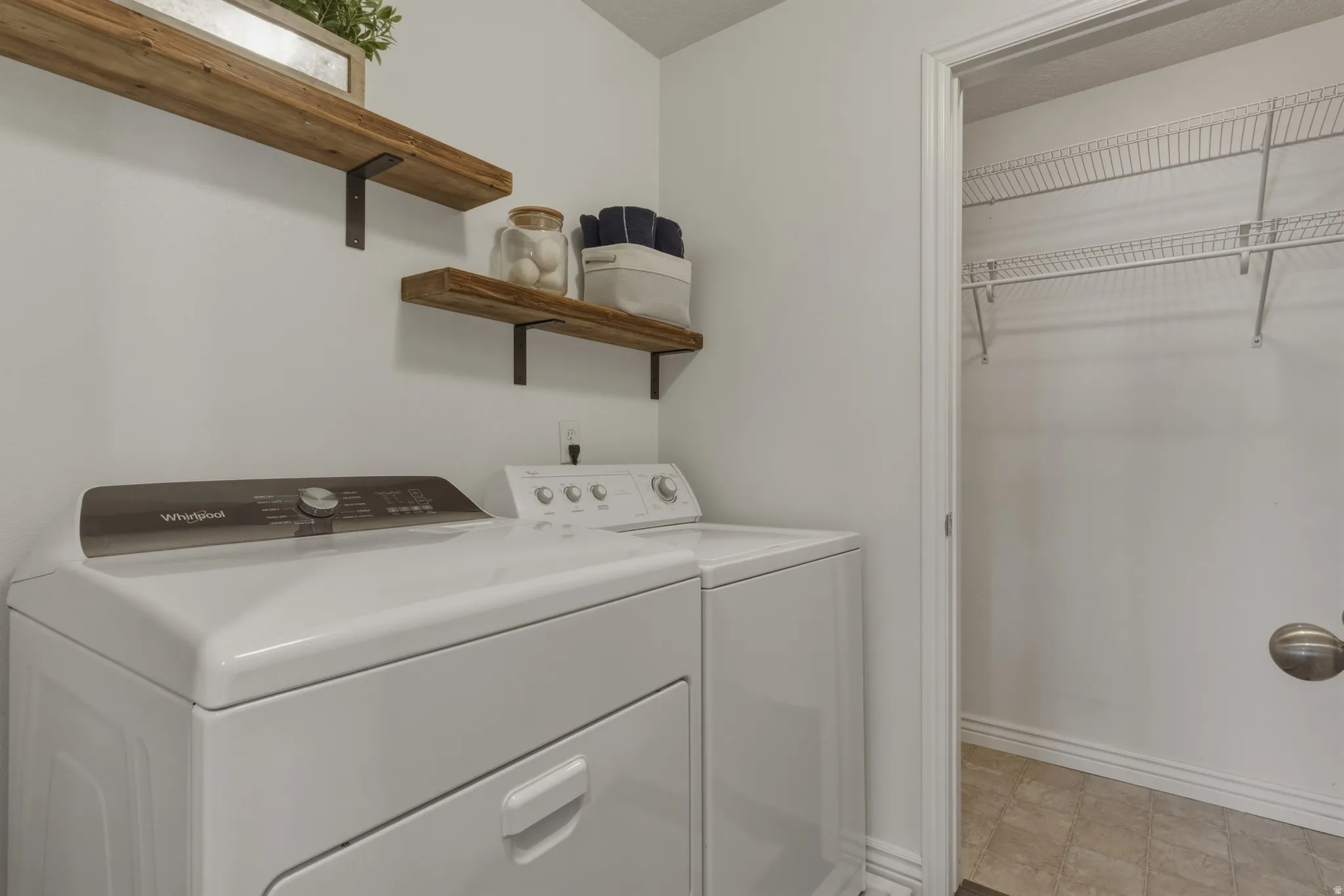 Laundry room featuring washing machine and clothes dryer and light flooring