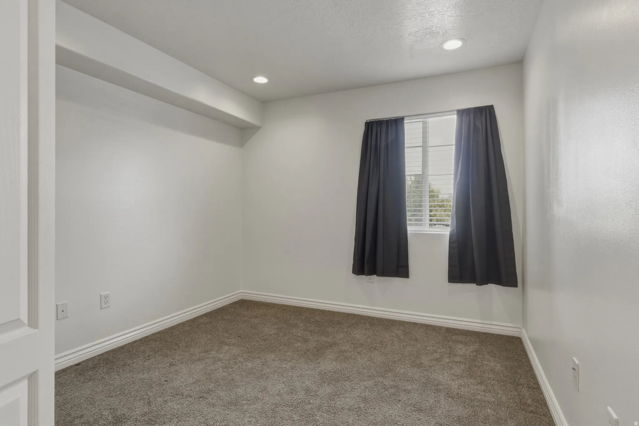 Empty room with carpet floors and recessed lighting