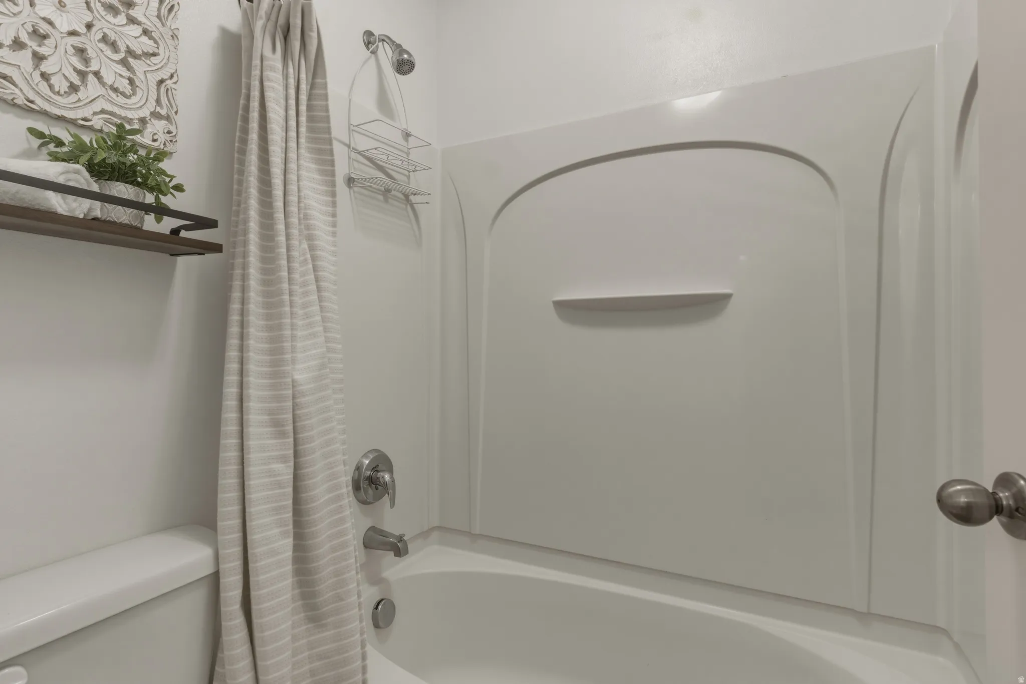 Full bath featuring shower / bath combo with shower curtain and toilet