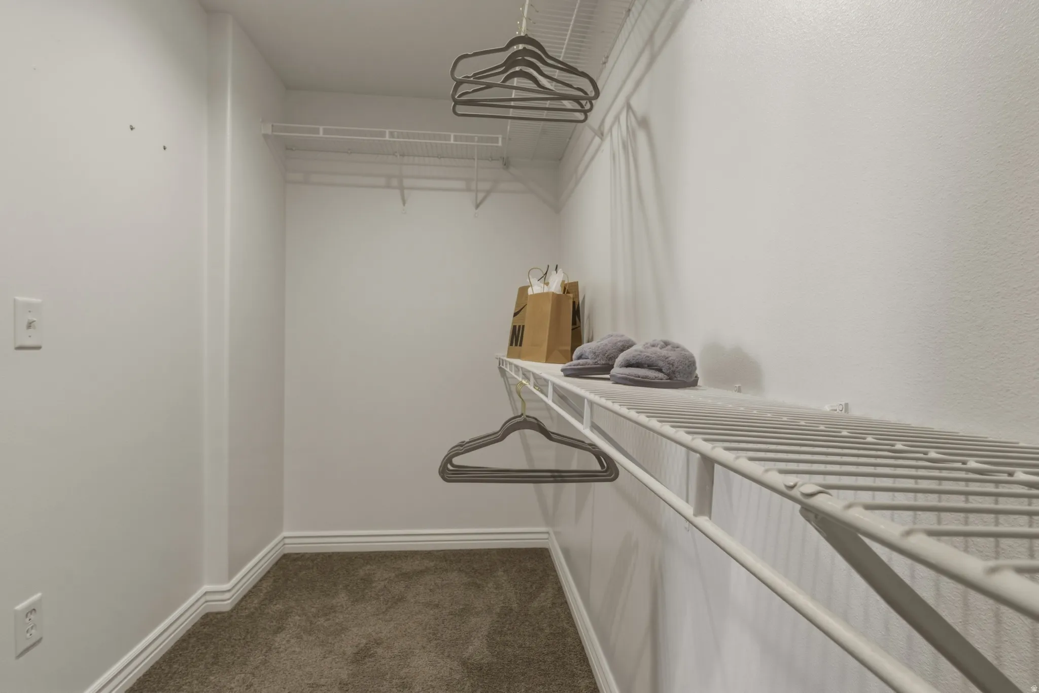 Walk in closet featuring dark carpet